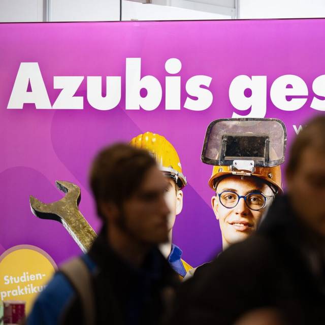 Besucher stehen auf der Jobmesse "KarriereStart" vor dem Schriftzug "Azubis gesucht"
