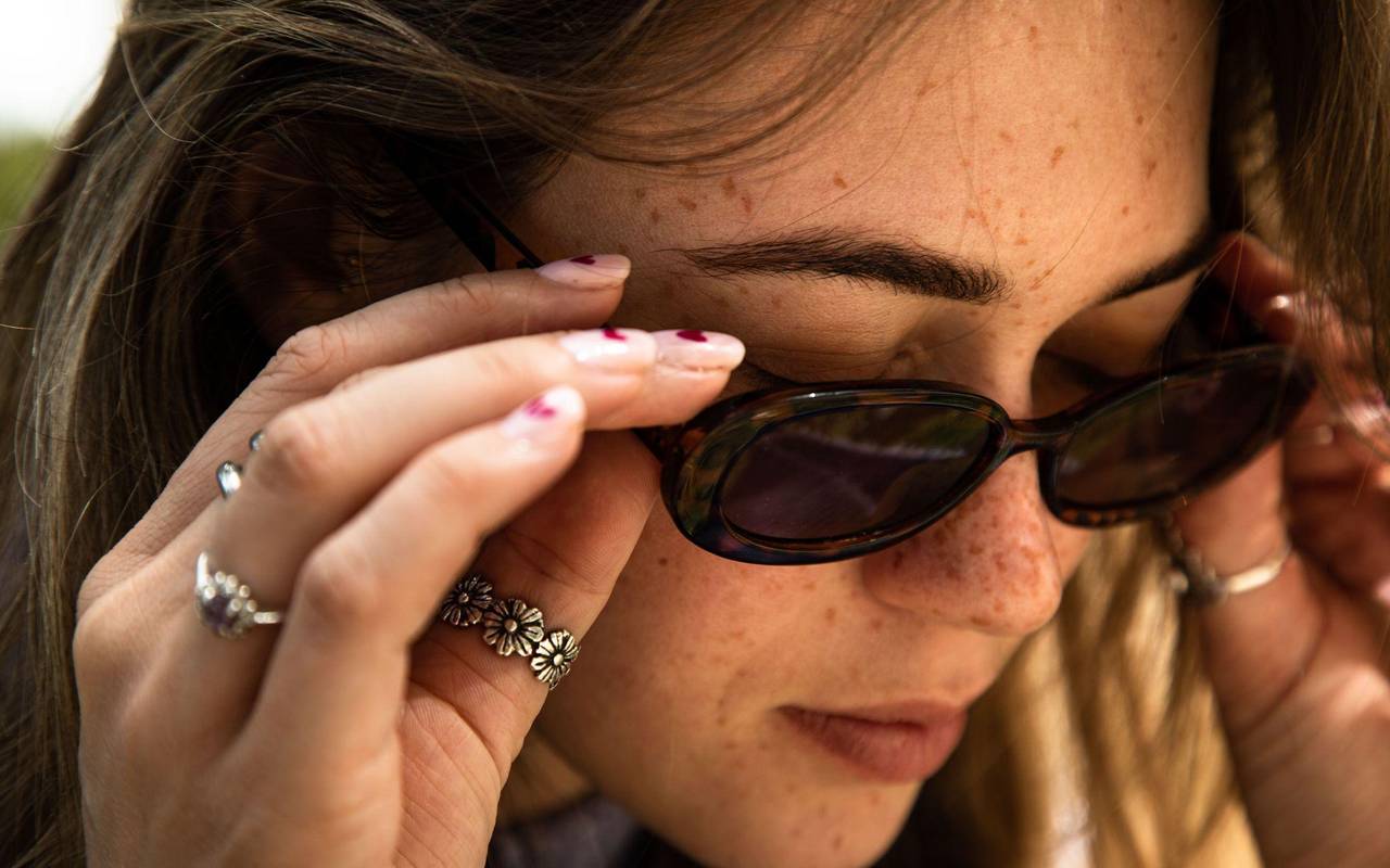 Eine Frau mit Sommersprossen und Sonnenbrille