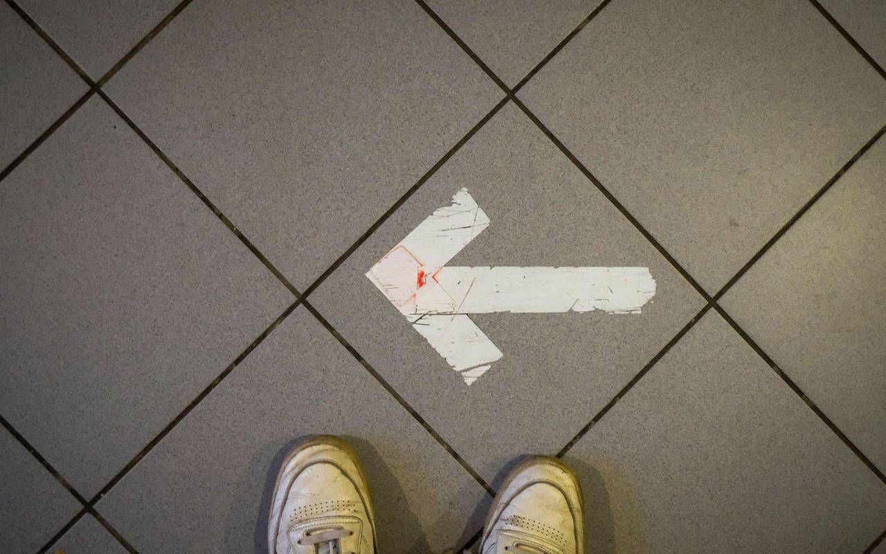 Ein Pfeil aus Klebeband ist auf einem Fußboden zu sehen