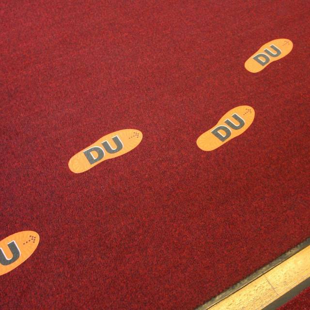 Aufgeklebte Fußstapfen mit der Aufschrift "DU"