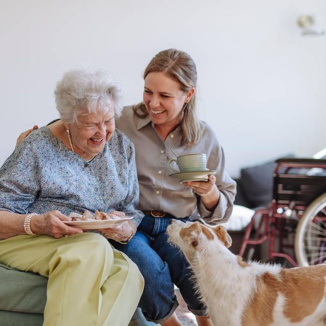 Frau betreut eine Seniorin in ihrer Wohnung