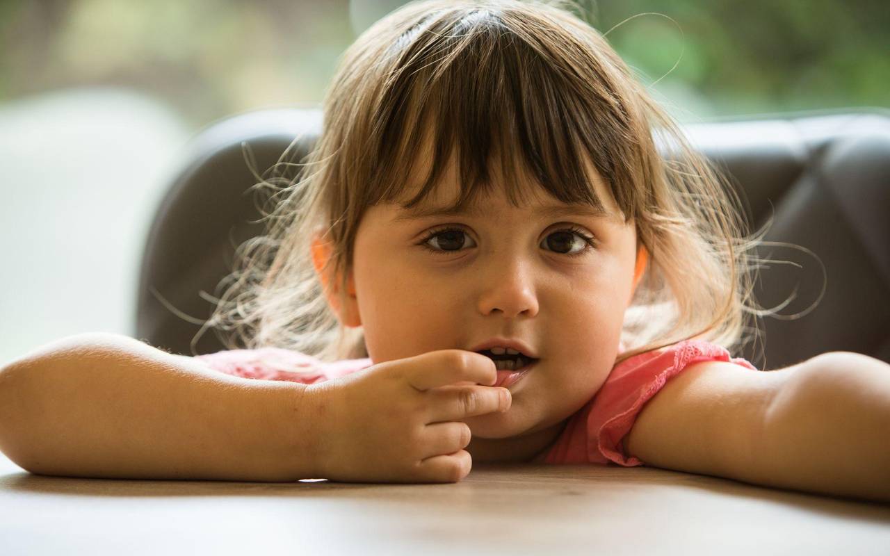 Ein Mädchen steckt sich etwas in den Mund
