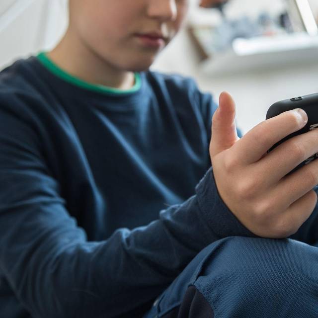 Ein Junge schaut auf sein Smartphone