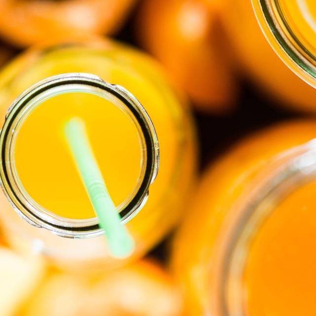 Ein Fruchtsaft in einer Glasflasche mit einem Strohhalm