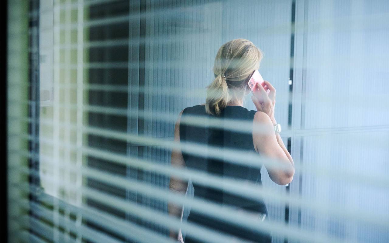 Frau steht telefonierend in einem Büro