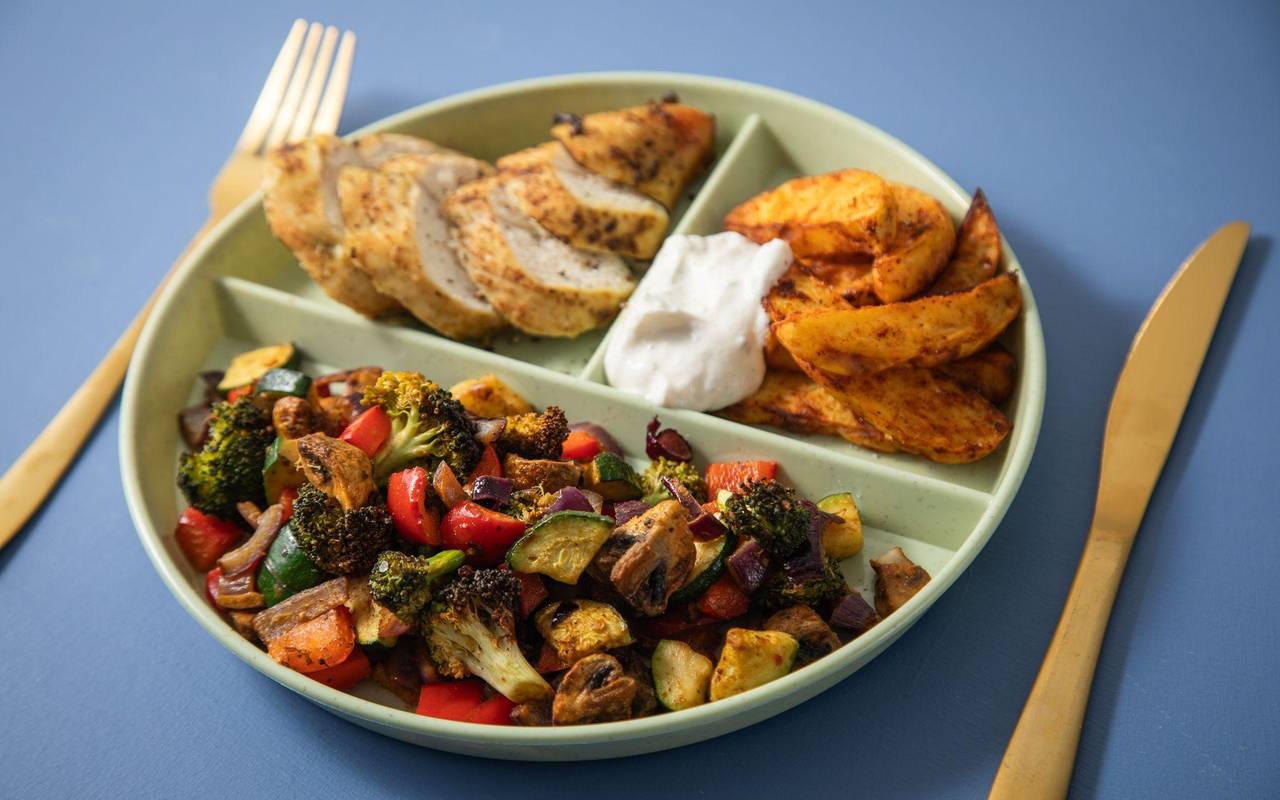 Hühnchenbrust, Kartoffelspalten, Kräuterquark und Röstgemüse