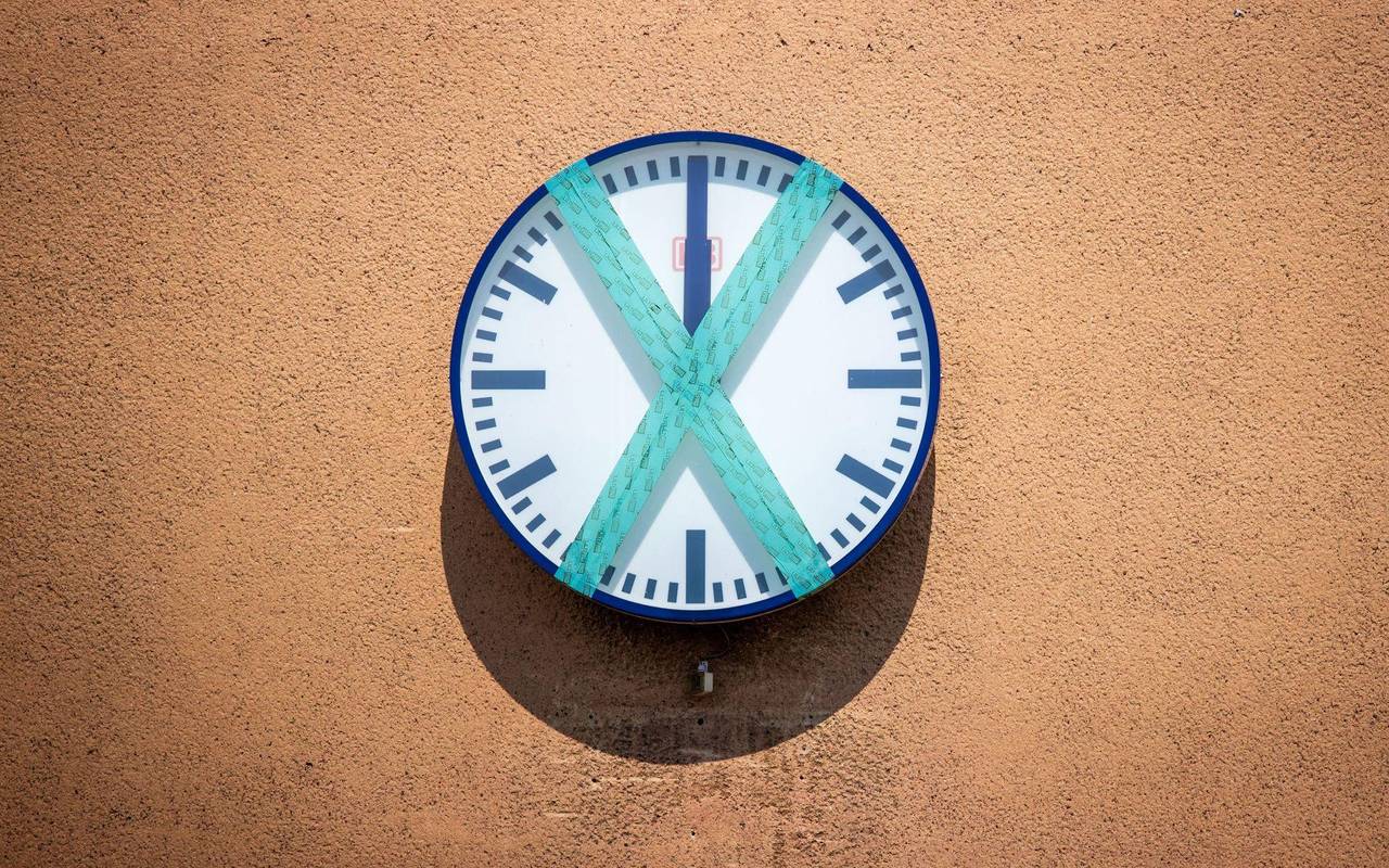 Eine abgeklebte Bahnhofsuhr hängt an einer Wand