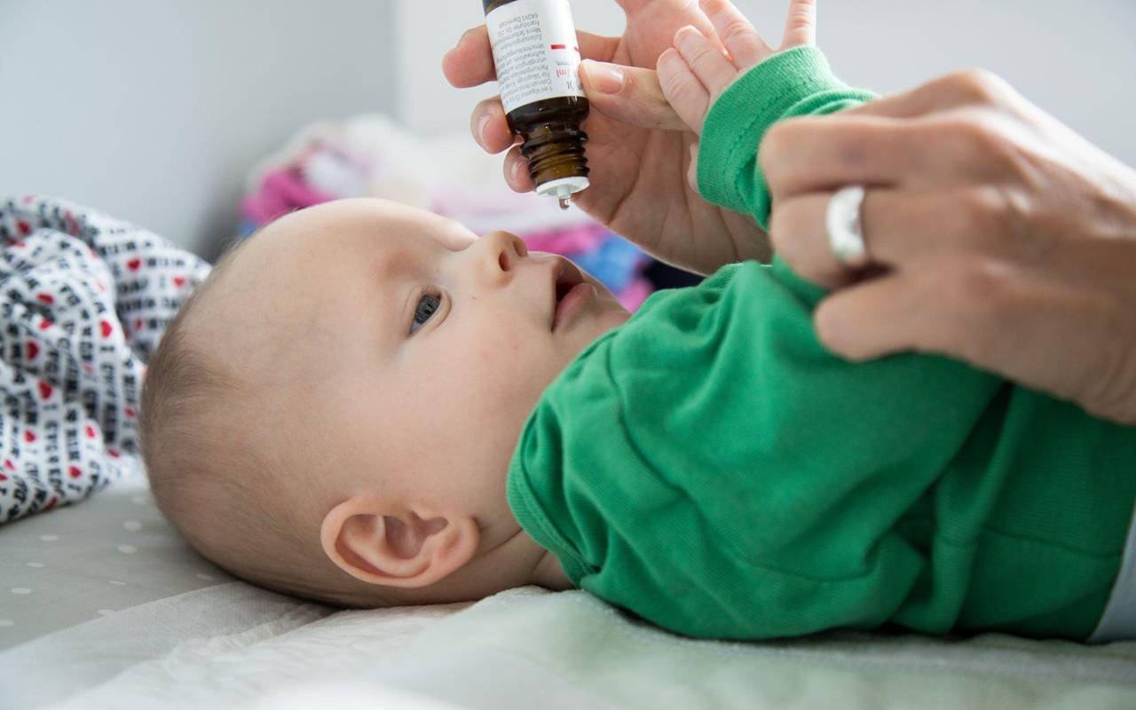 Eine Mutter verabreicht ihrem Baby Vitamin-D-Tropfen