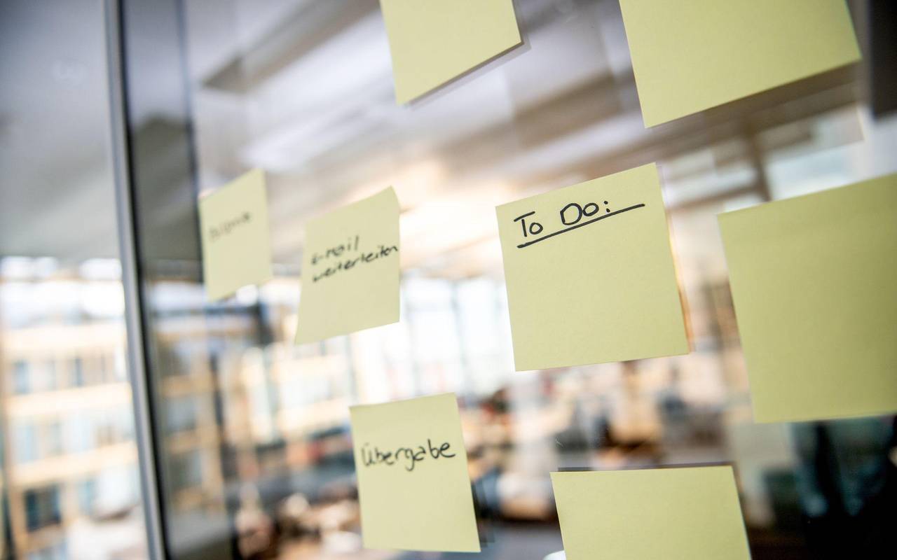 Notizzettel mit den Worten To Do kleben in einer Scheibe im Büro