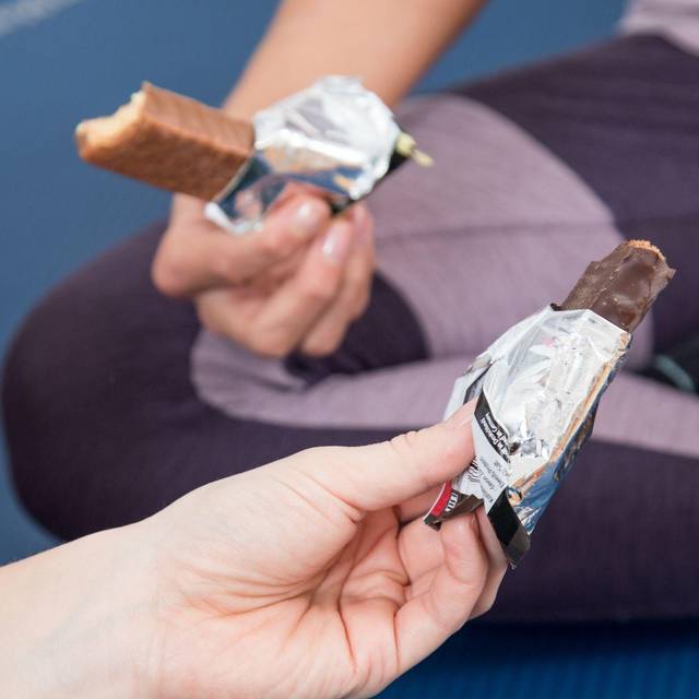 Zwei Personen halten Schokoriegel in den Händen