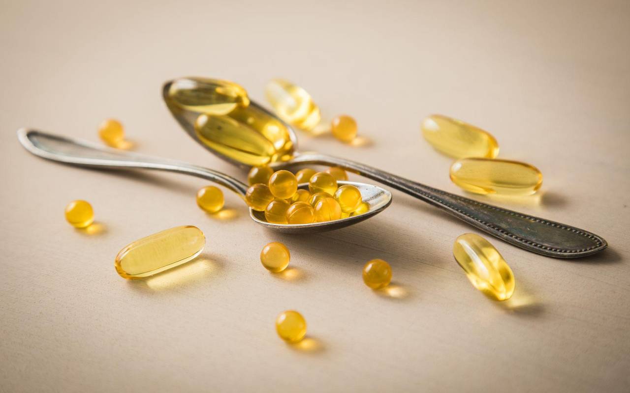 Tabletten und Kapseln liegen auf Löffeln