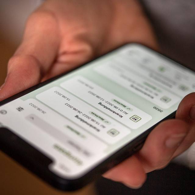 Eine elektronische AU ist auf dem Display eines Handys zu sehen