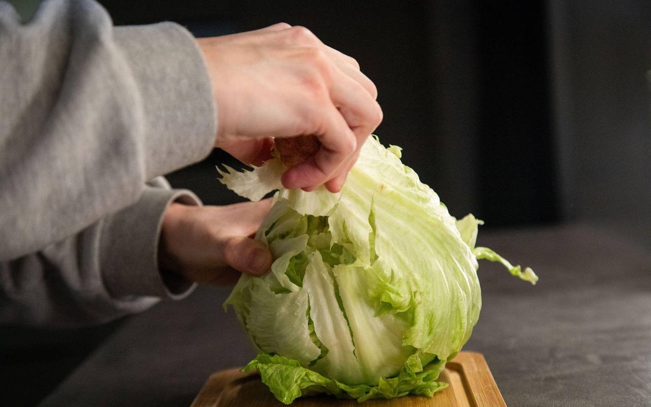 Der Strunk eines Salatkopfs wird entfernt