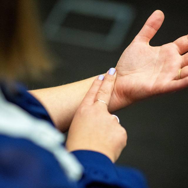 Eine Frau misst ihren Puls am Handgelenk