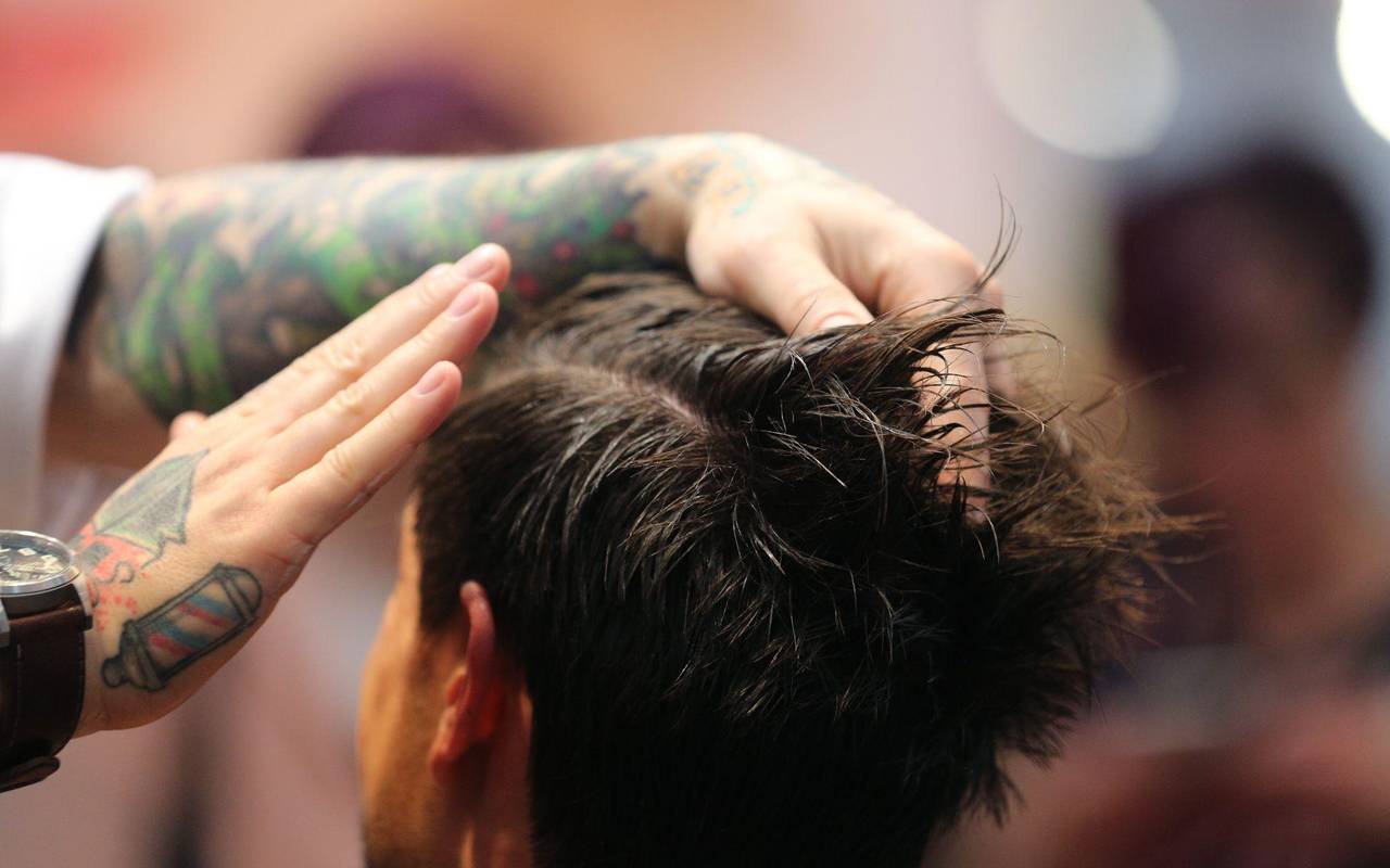 Friseur stylt die Haare eines Mannes mit Haargel