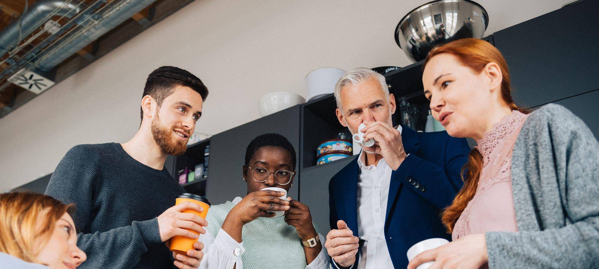 Eine Gruppe Kollegen verbringt ihre Pause in einer Büroküche