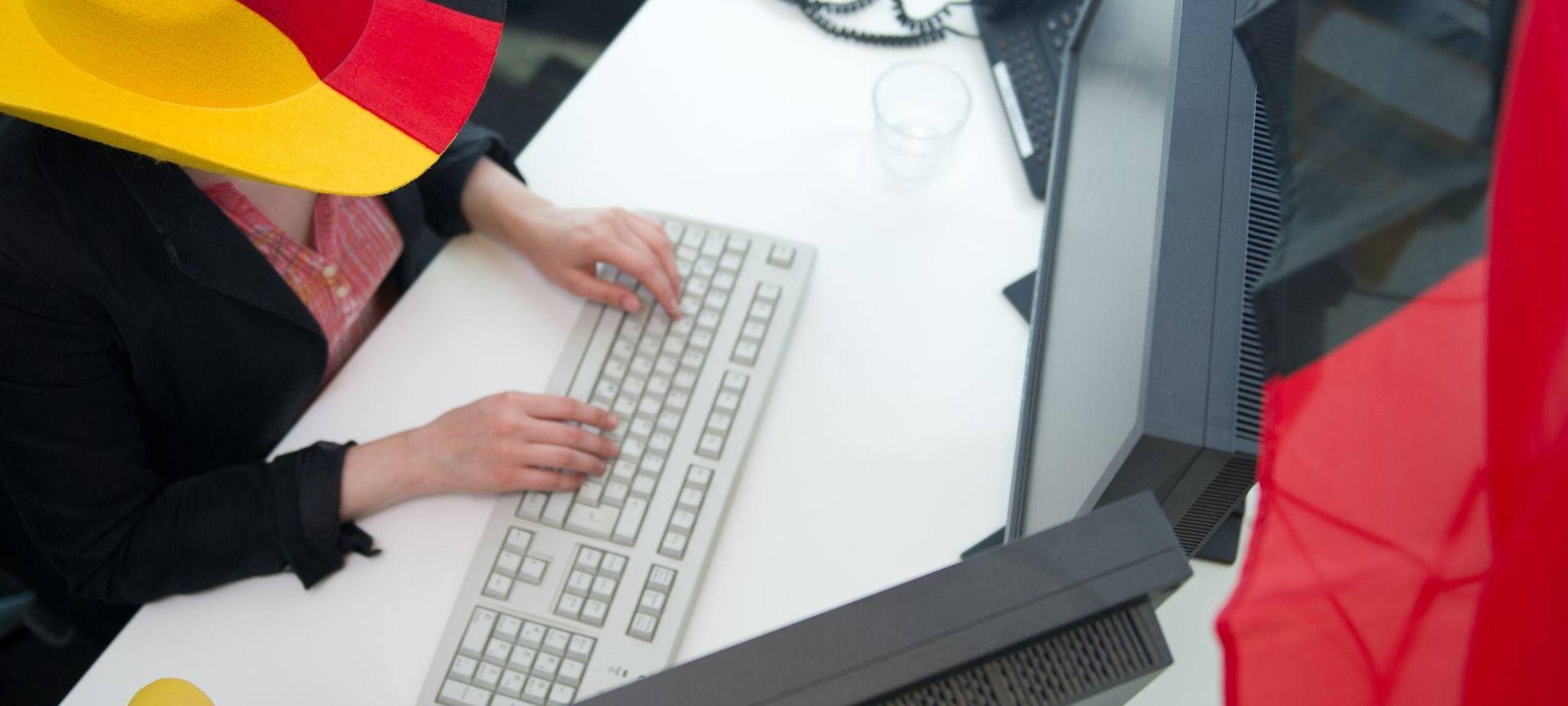 Eine Frau in Fankleidung am Arbeitsplatz