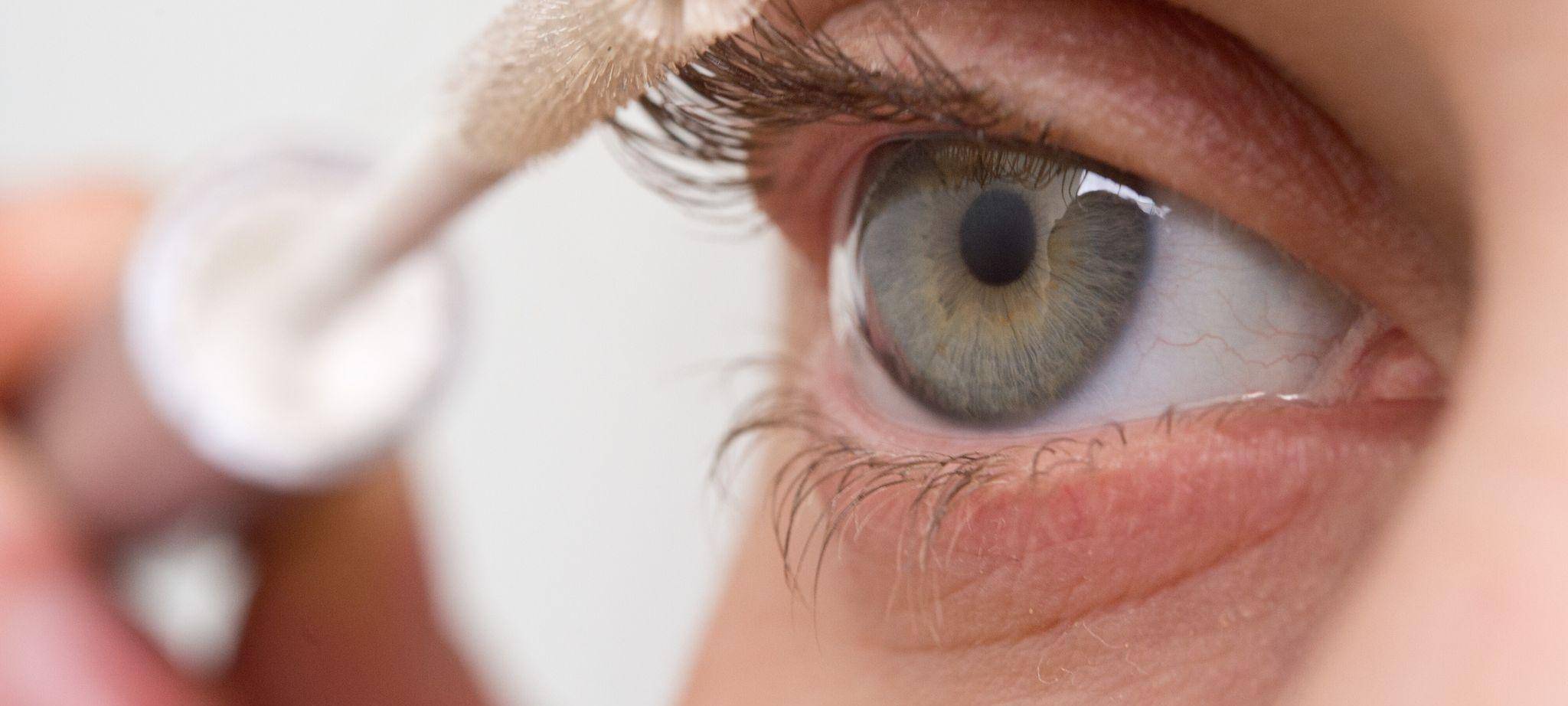 Eine Frau tuscht ihre Wimpern mit Wimpernserum