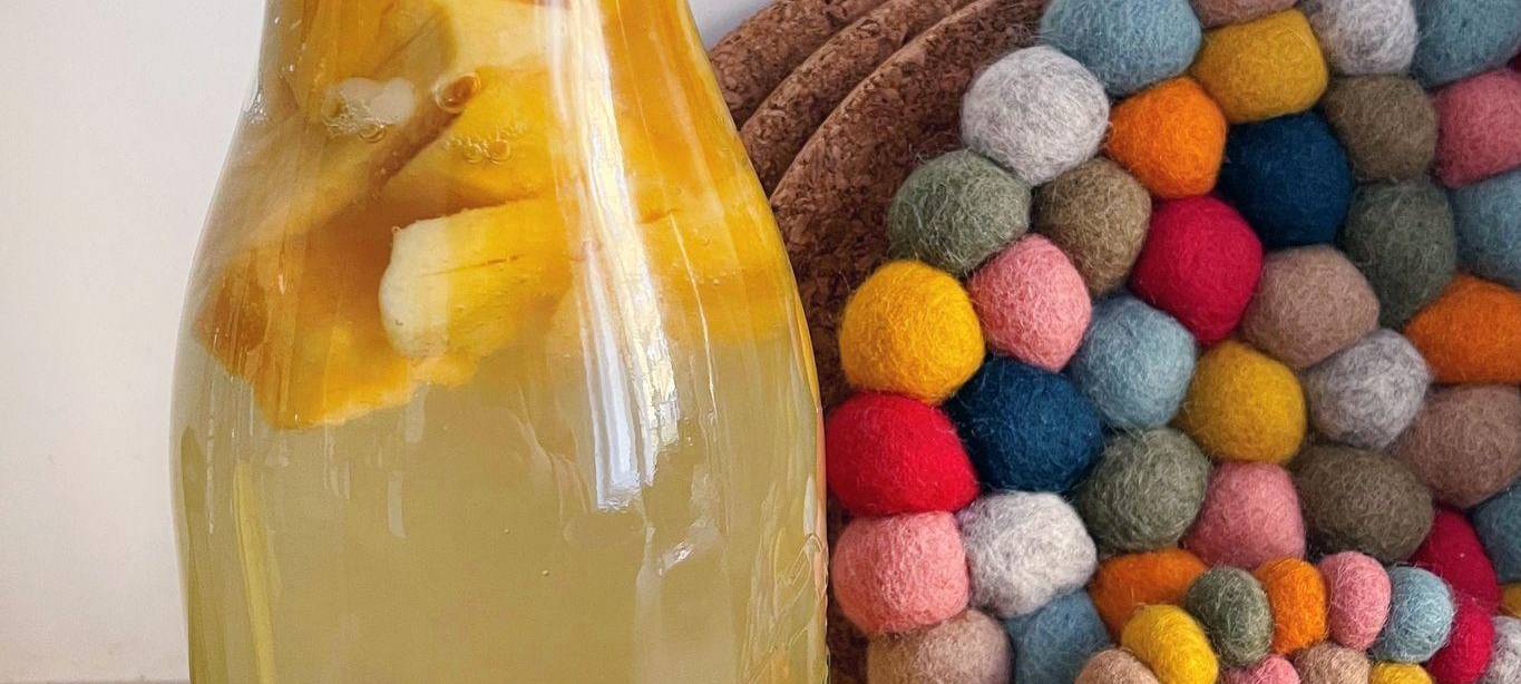 Mangostreifen und Kefirkristalle in einer Flasche mit Wasserkefir