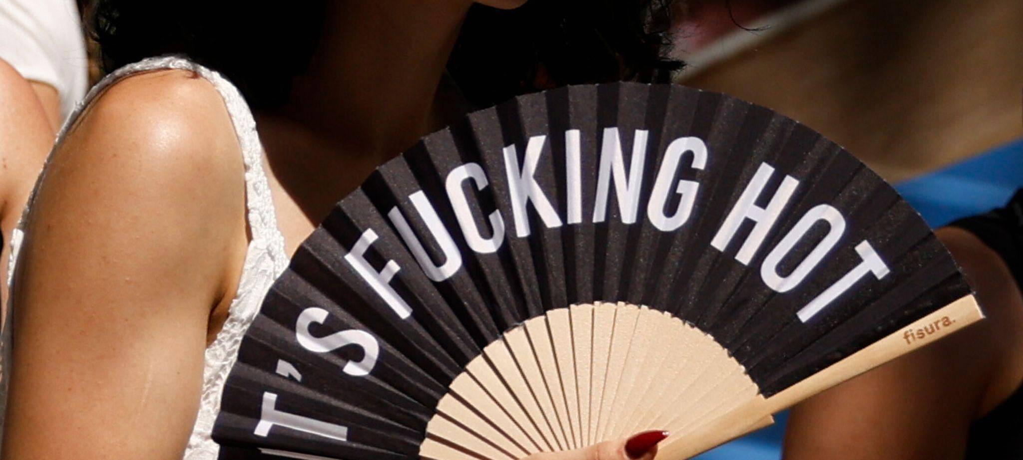 «Its Fucking Hot» steht auf dem Fächer einer Frau