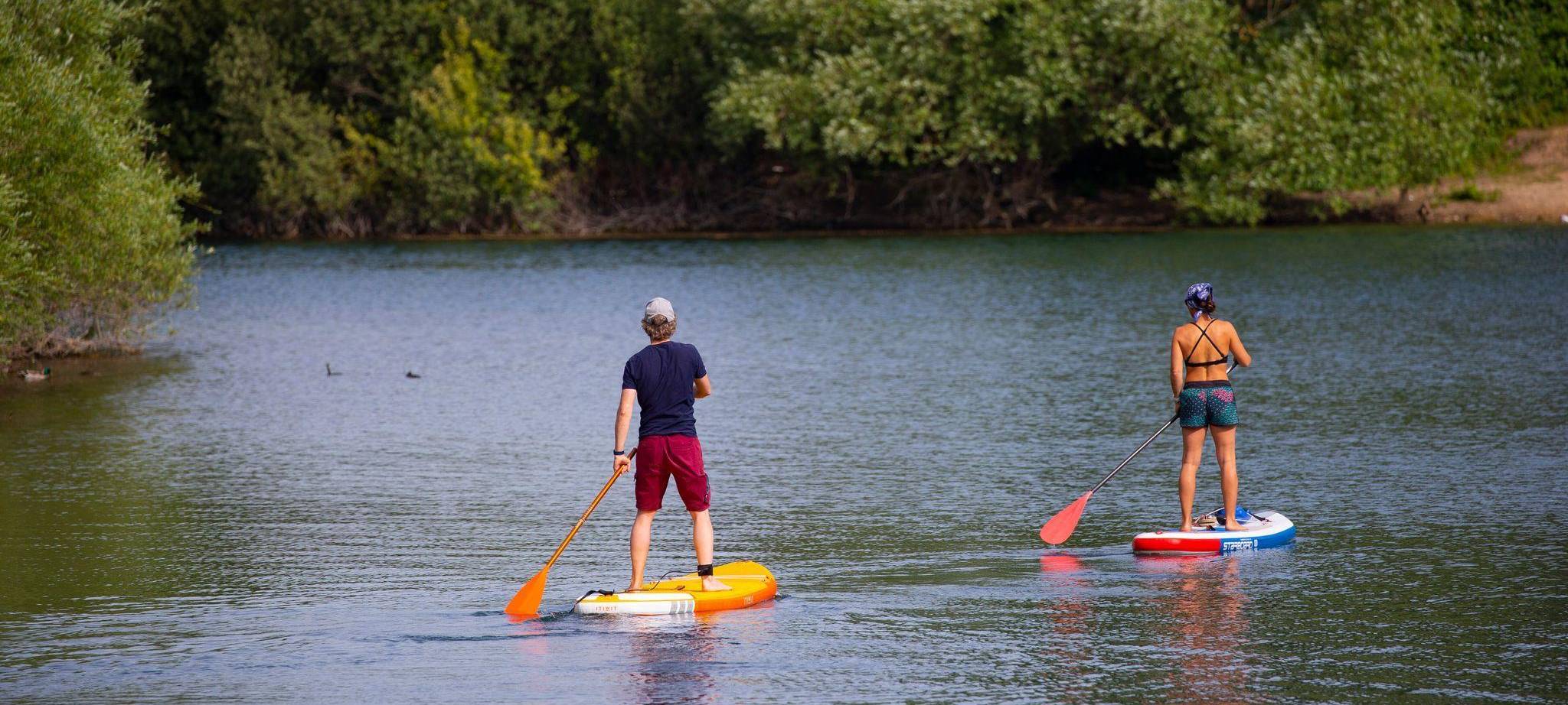 Zwei Stand-Up-Paddler gleiten über den Fühlinger See